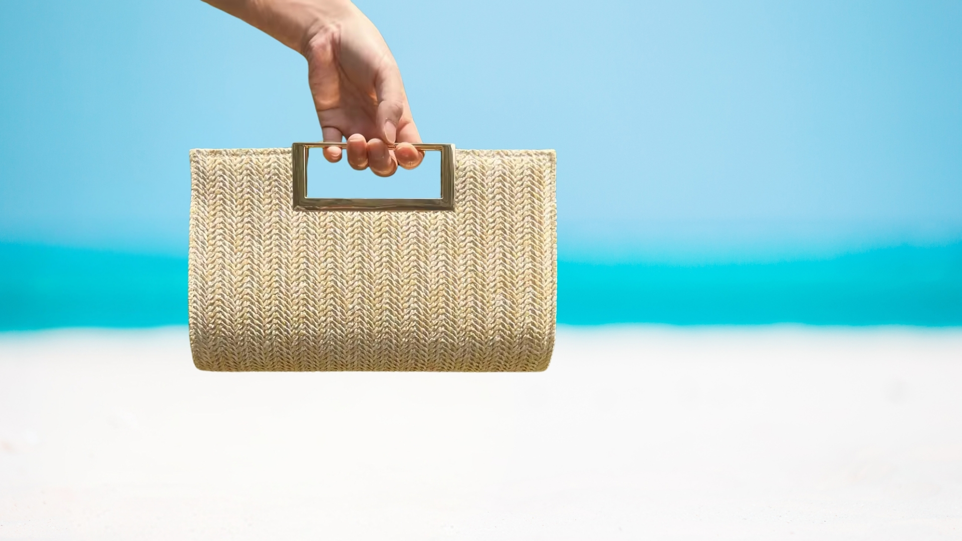 Main tenant un sac en paille Arranjo